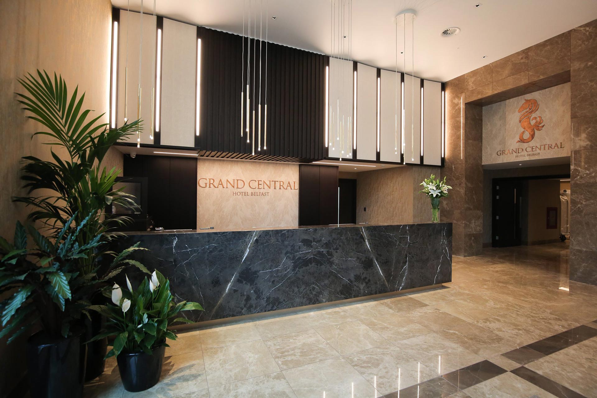 Recepció d’hotel amb taulell de marbre i il·luminació suspesa