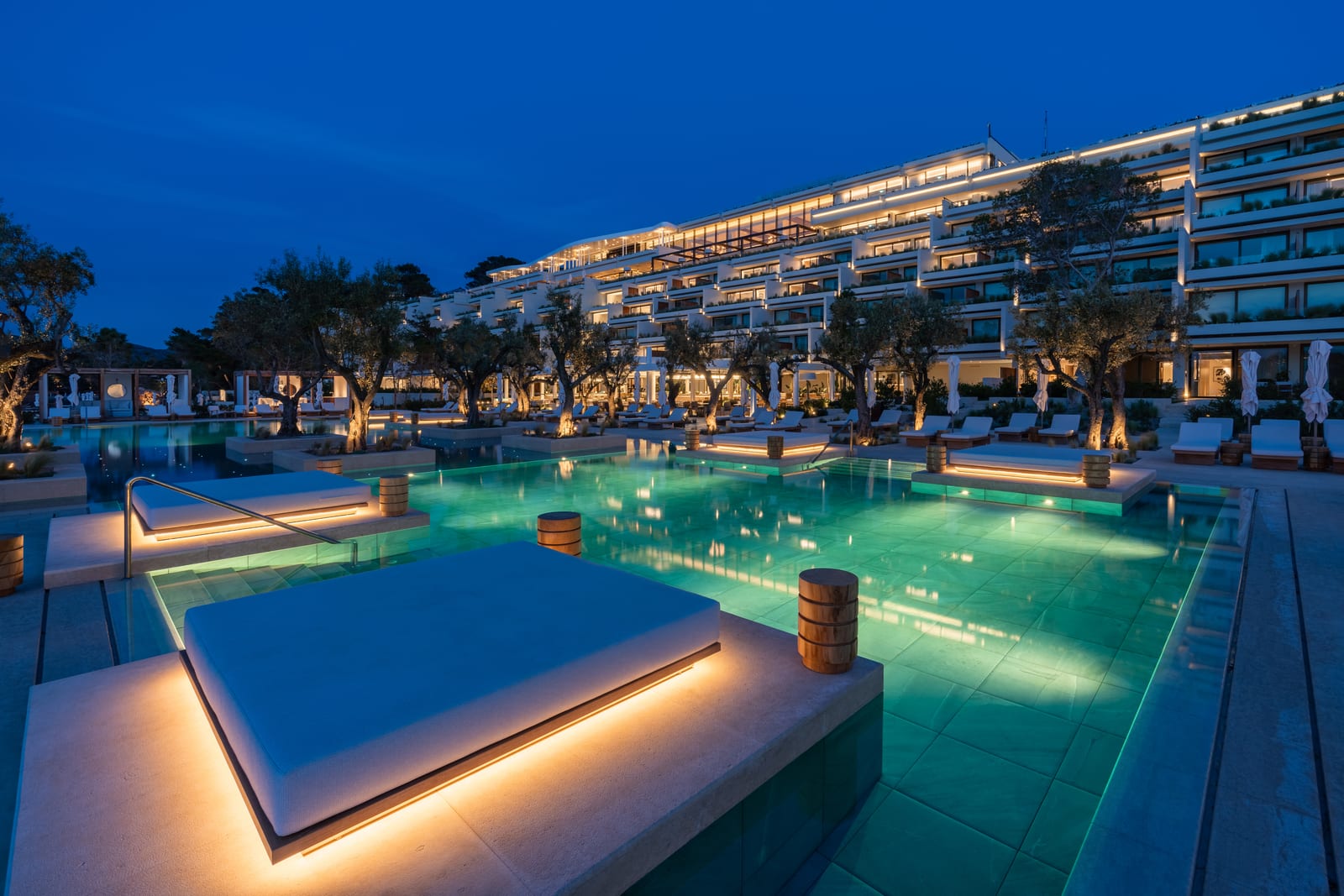 Il·luminació de piscina i paisatge Linea Light en un complex turístic grec amb oliveres