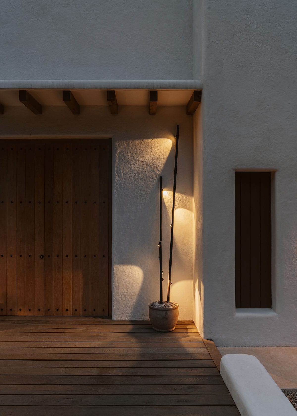 Llum Vibia Bamboo en un test de terracota davant d'una paret emblanquinada