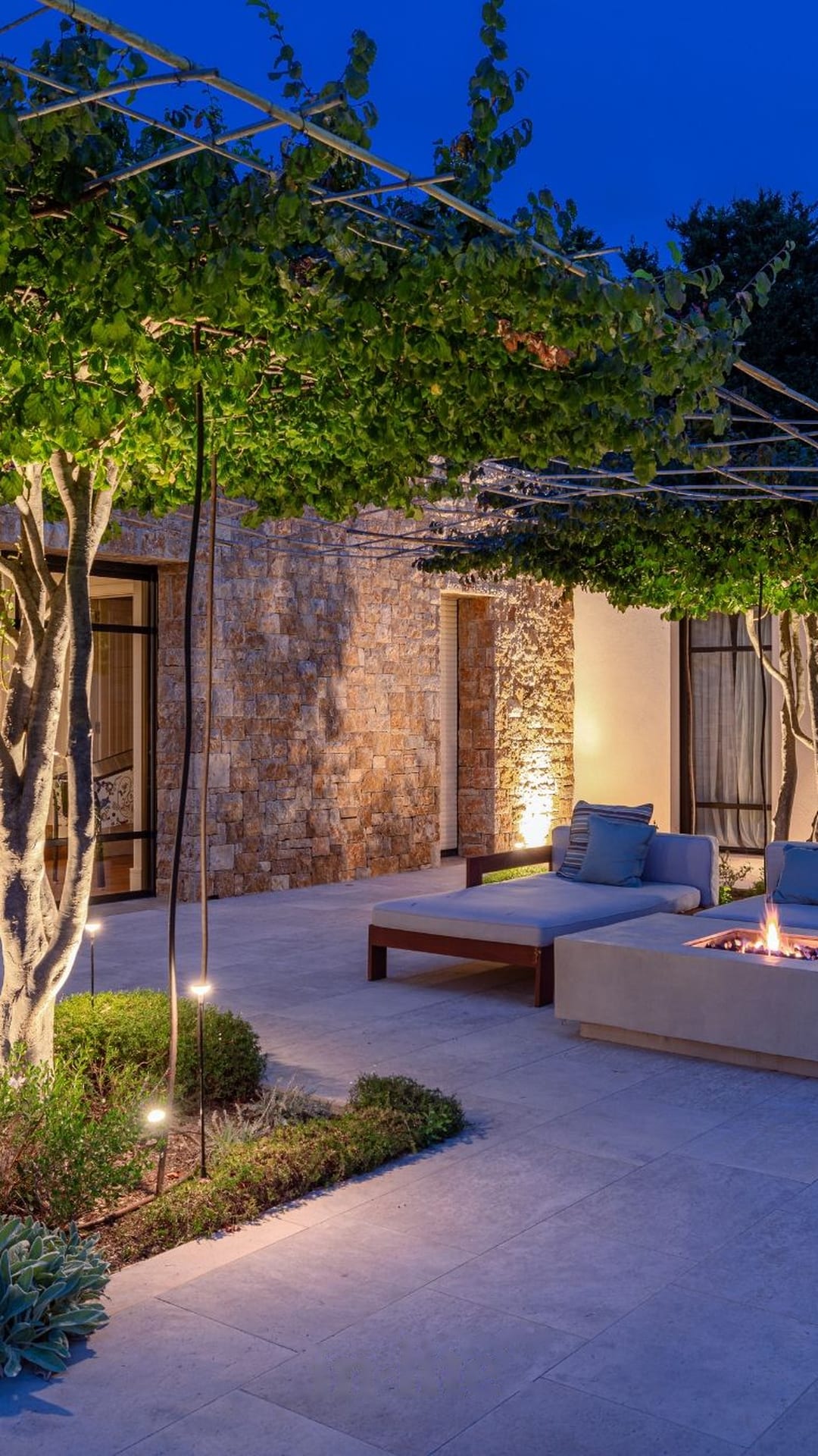 Terraza con pérgola y brasero en una finca de piedra